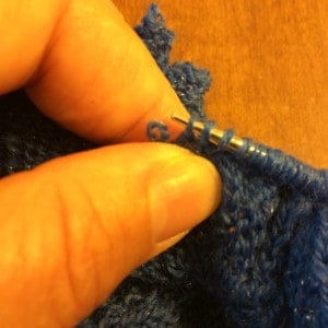 Pinching the base of the stitch to be picked up helps you get it on the needle without dropping any stitches.