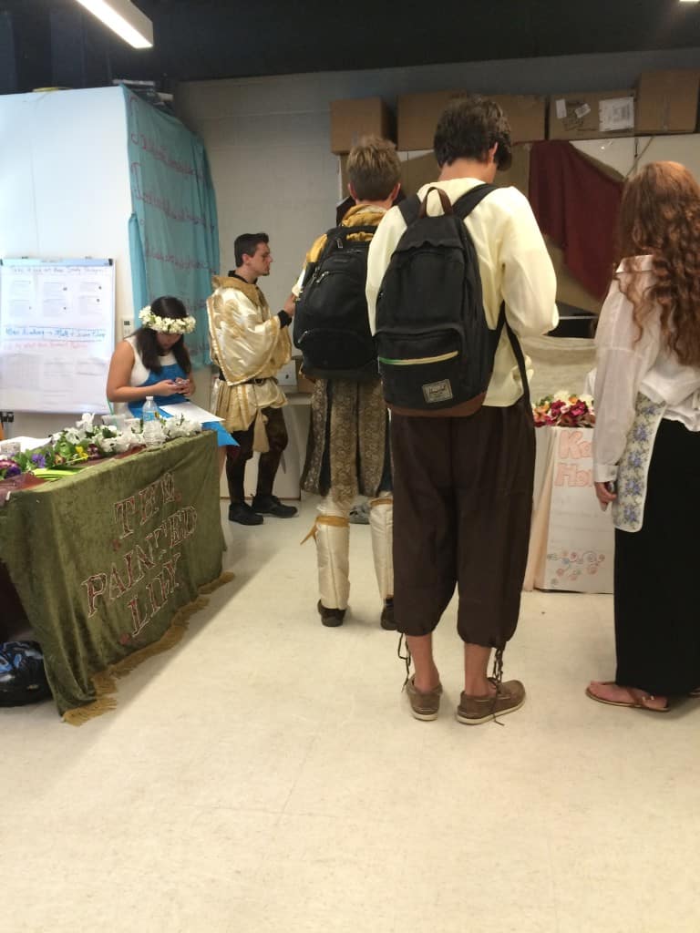 An English  teacher (on the left, in the knight costume) explaining the passports to a class.